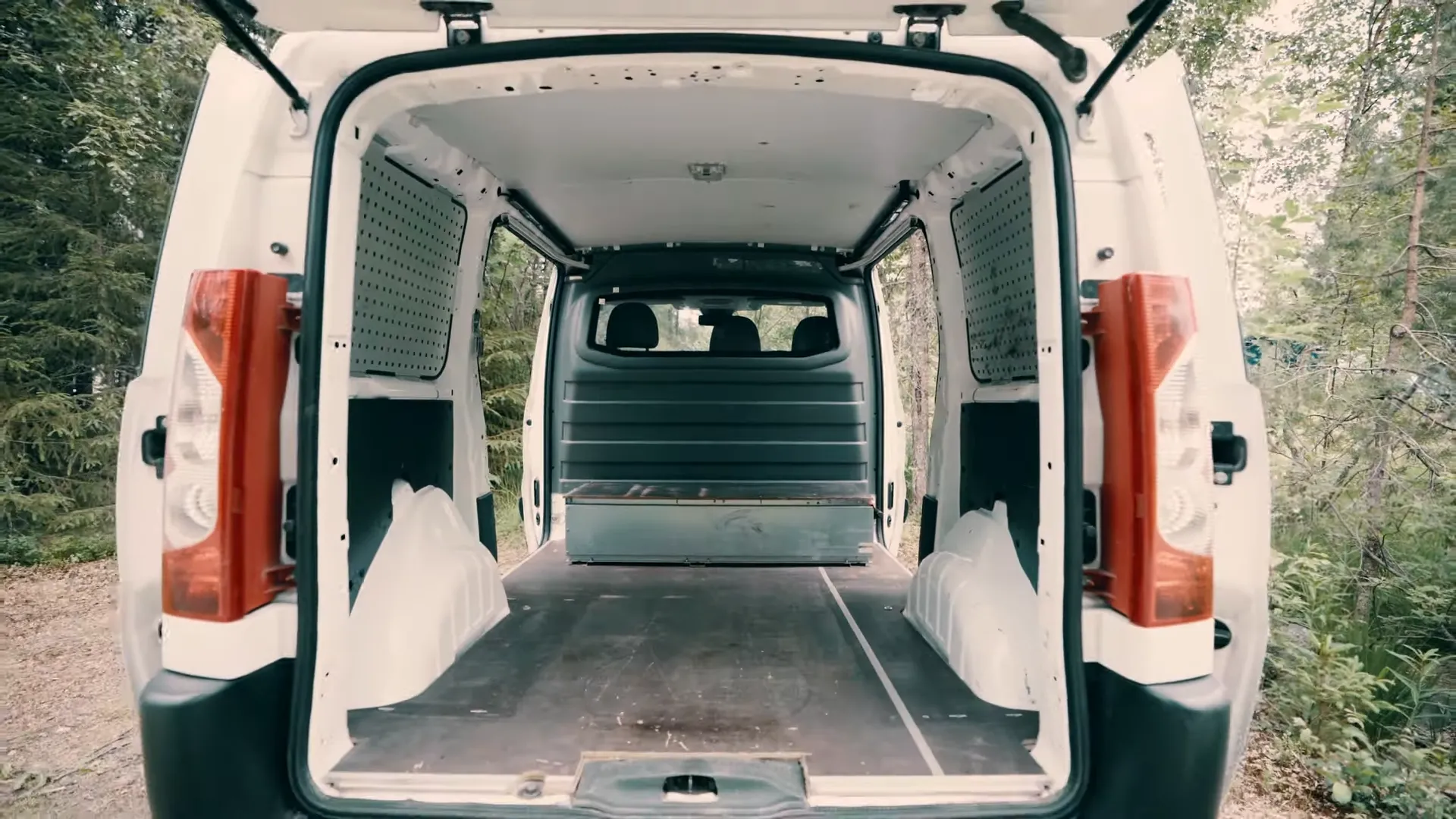 Intérieur vide d’un Toyota Proace avant aménagement, portes arrière ouvertes sur la carrosserie brute, point de départ d’un budget d’aménagement van